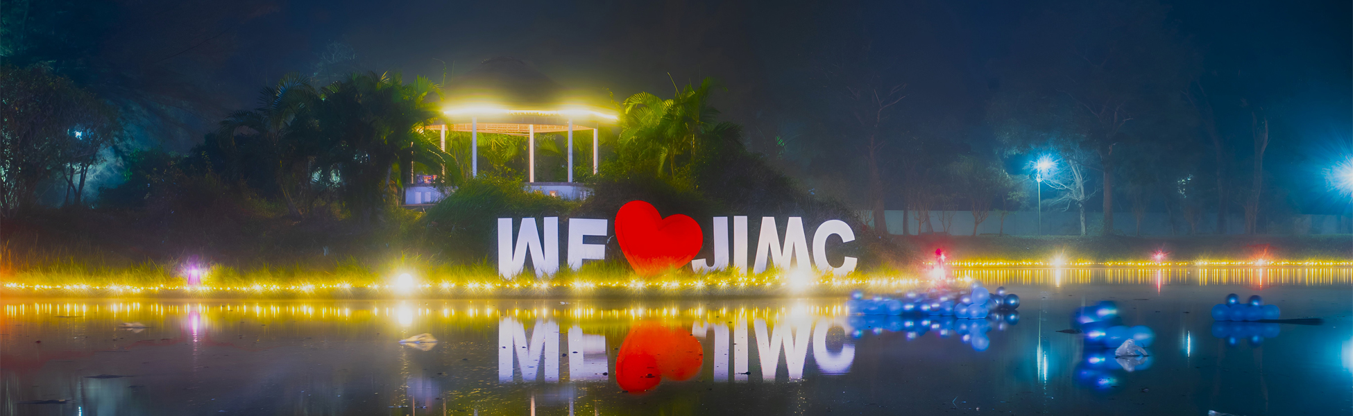 JIMC campus at night, lake-side pavilion lit up